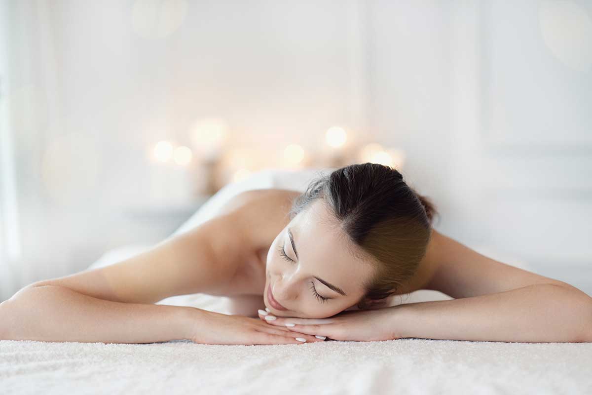 mujer morena tumbada relajada,bien maquillada maquillada, con pestañas y uñas bonitas